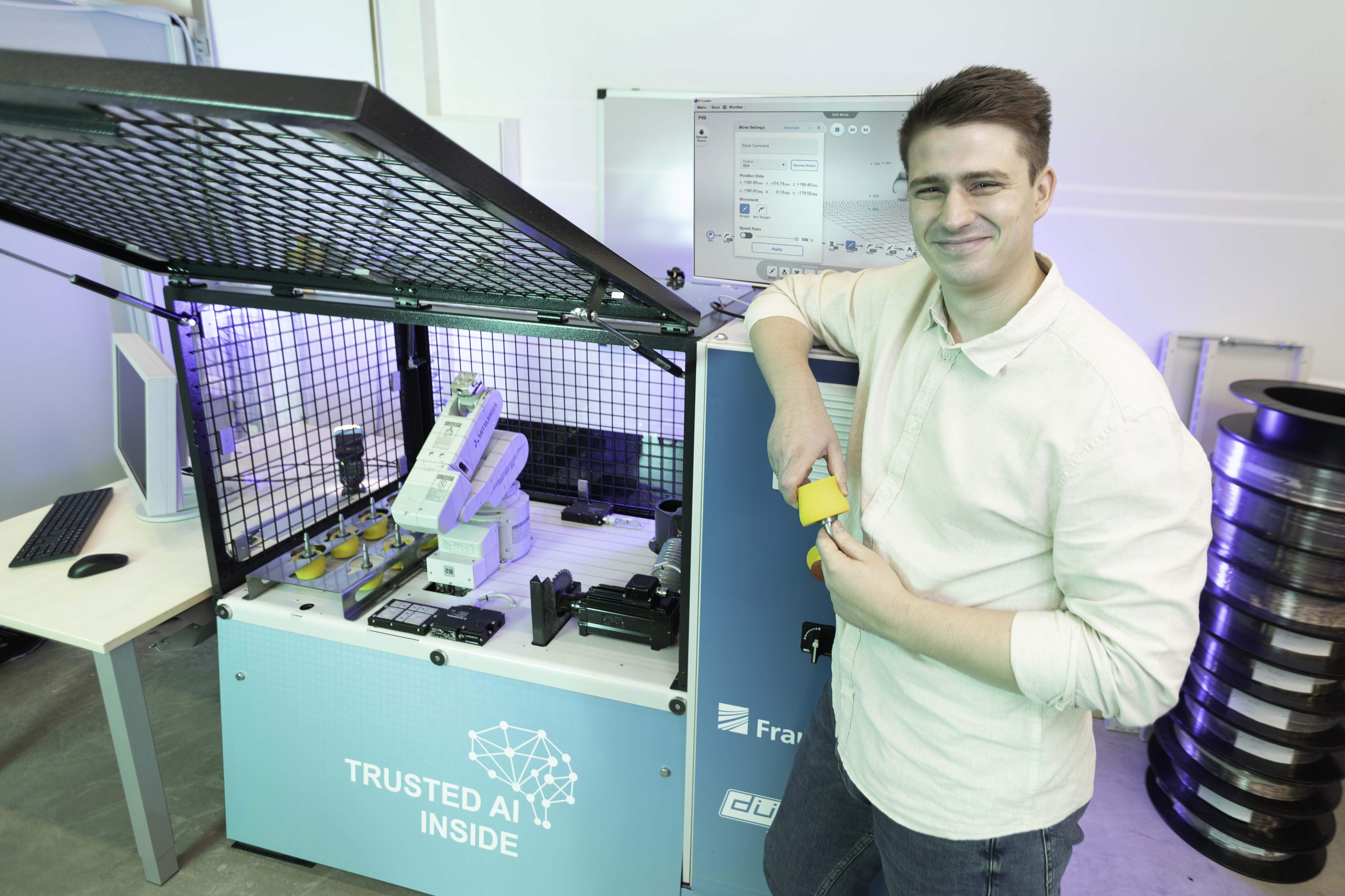 Steven Koppert steht mit einer Gummirolle vor dem sogenannten Robo Grinder, einem automatisierten Schleifsystem.