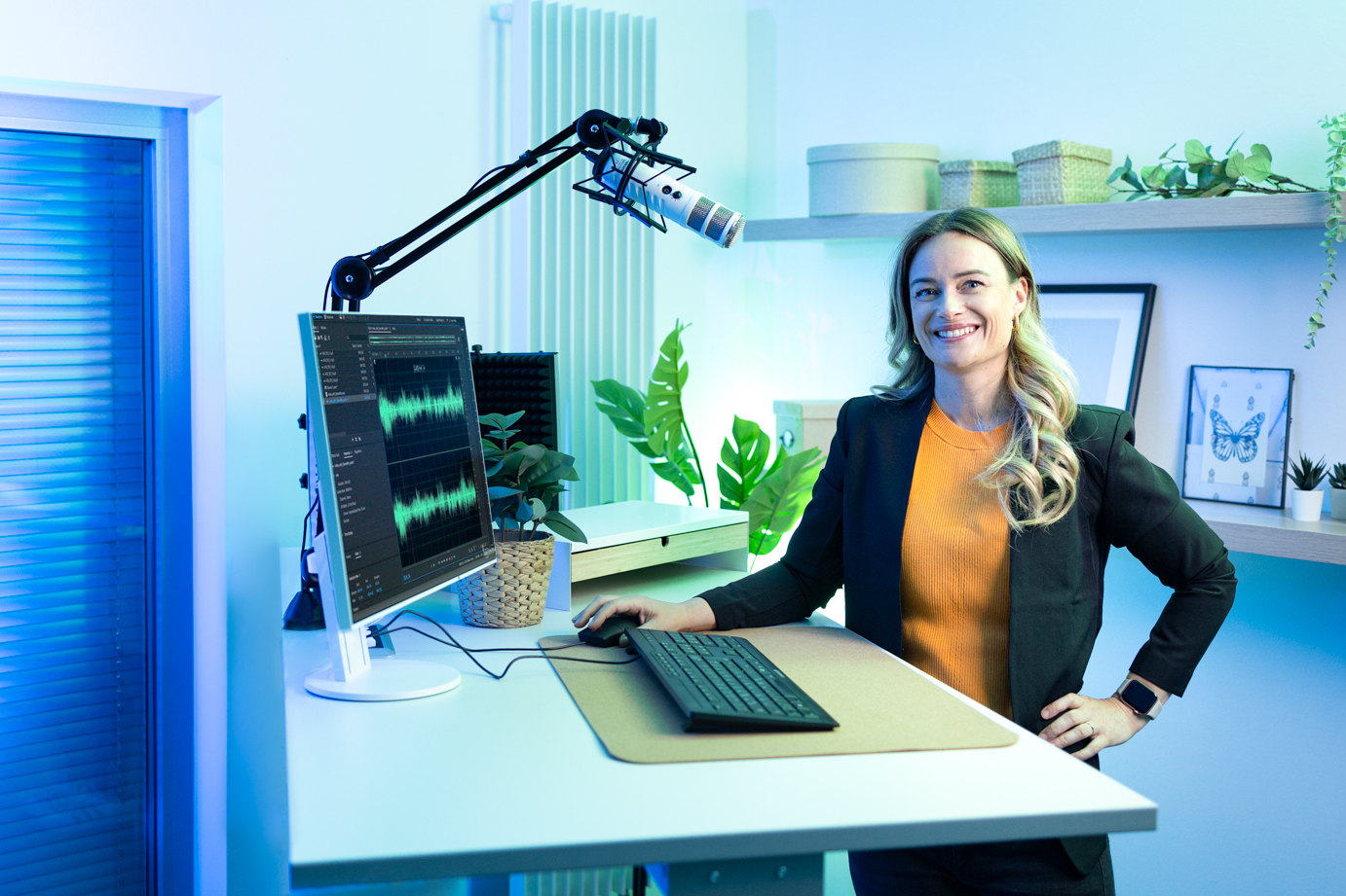 Katharina Altemeyer steht im Videostudio an einem Tisch, ausgestattet mit Mikrofon und Aufnahmesoftware.