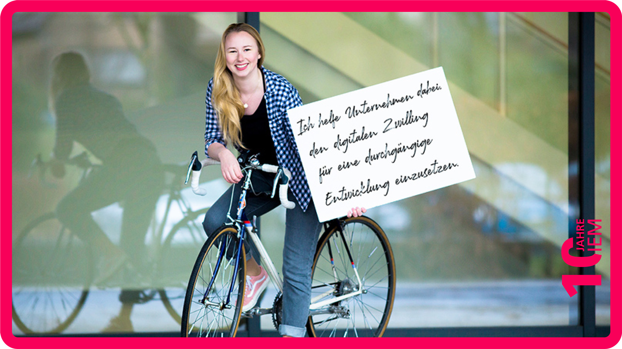 Alina Hellweg auf einem Fahrrad vor der ZM1 mit einem Schild in der Hand, auf der ihr Einsatz steht.