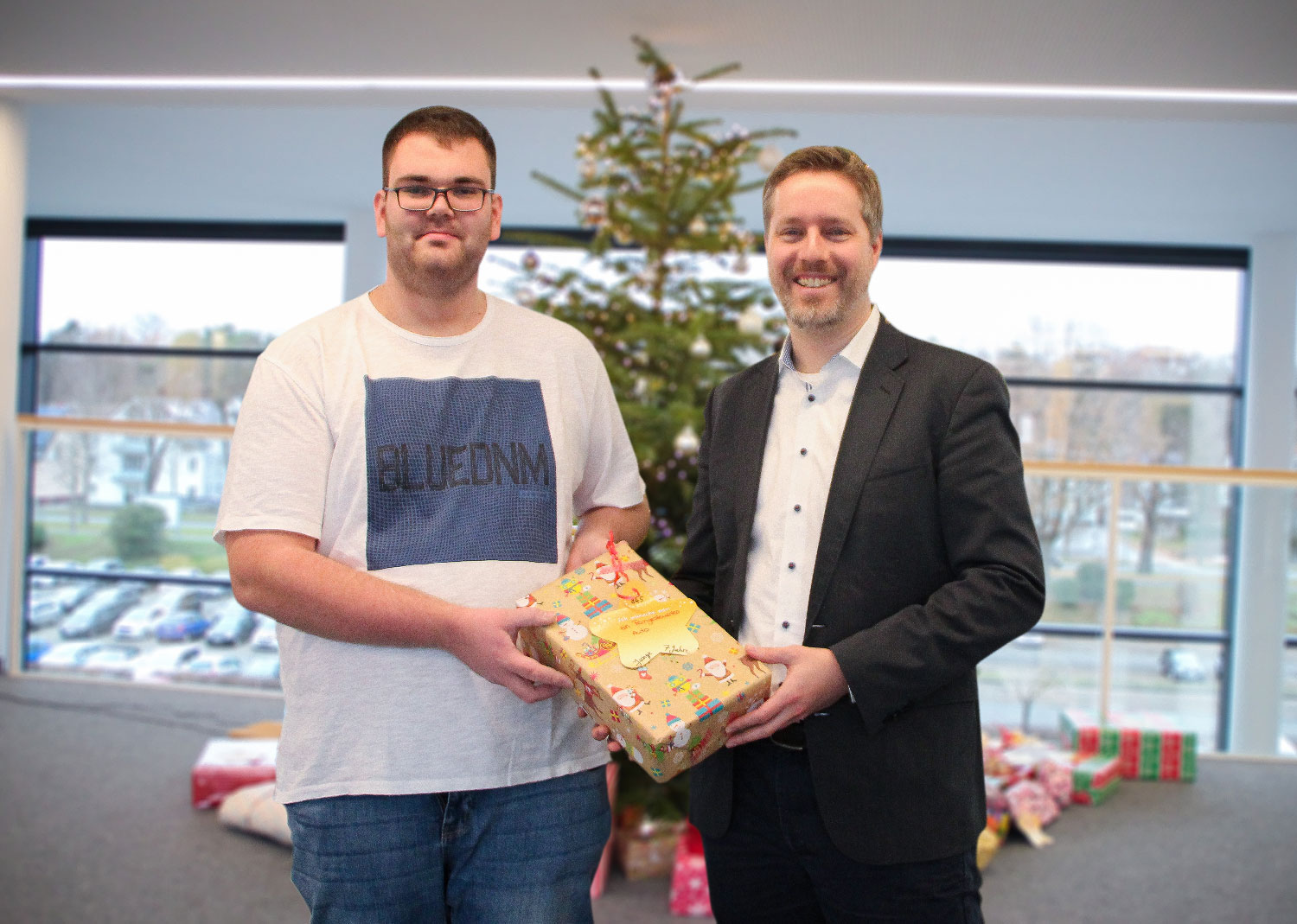 Unterstützung der DRK-Weihnachtsaktion: Prof. Eric Bodden (Direktor am Fraunhofer IEM) übergibt 40 Geschenke an Andre Kortmann (Jugendrotkreuz Paderborn).