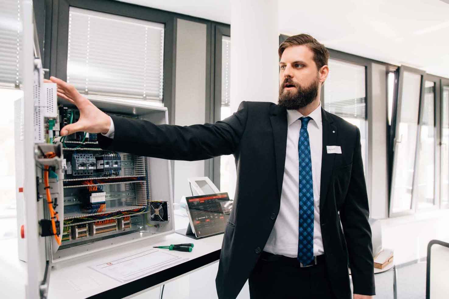 Matthias Greinert (Fraunhofer IEM) zeigt am Demonstrator im Systems Engineering Live Lab die digitale Montageanleitung eines Schaltschranks.