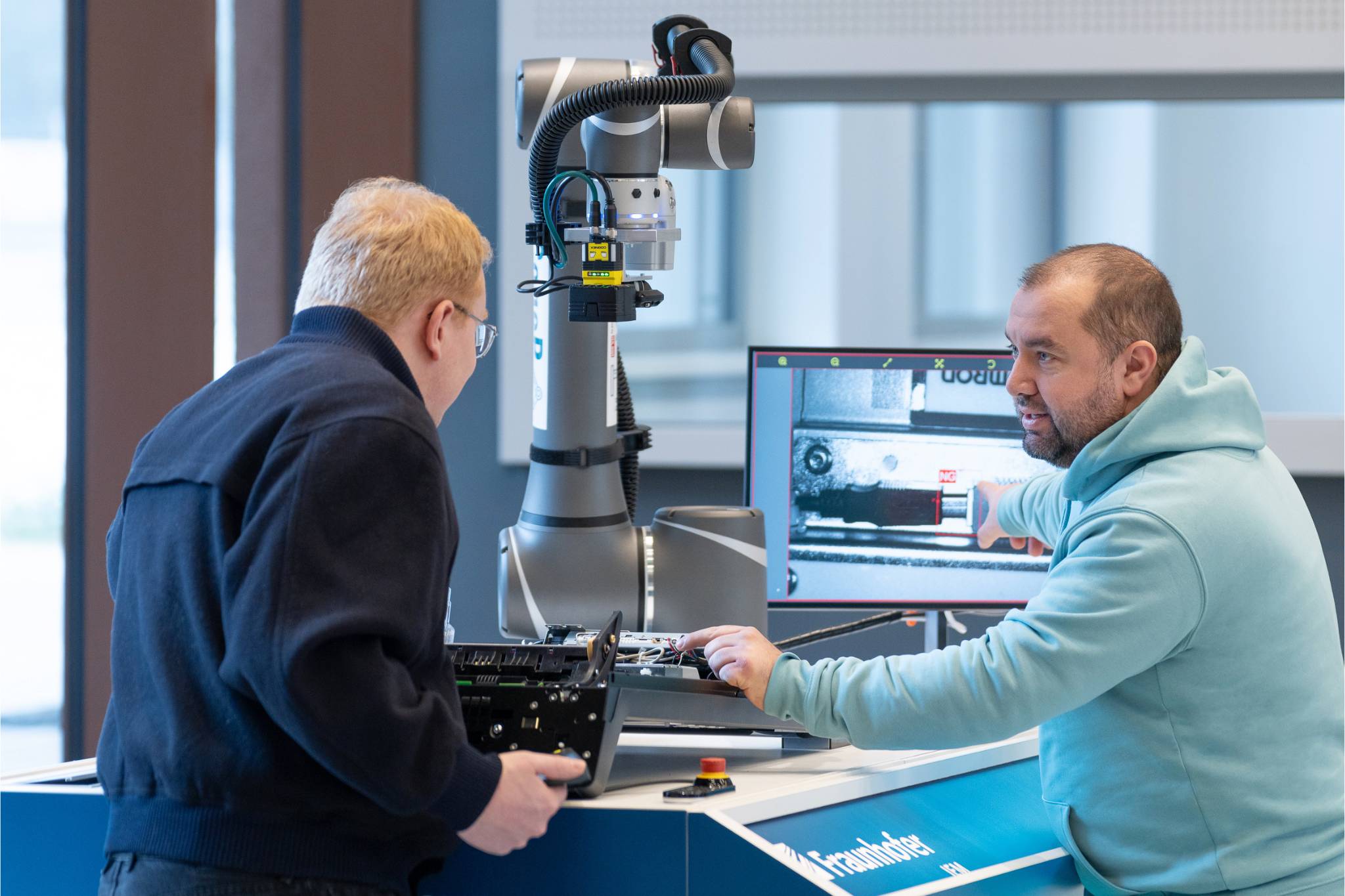 Cobot Prüfstation Zwei Männer stehen am Prüfstand