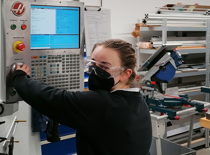 News Betriebspraktikum Sabine Ein Mädchen bedient eine Maschine.