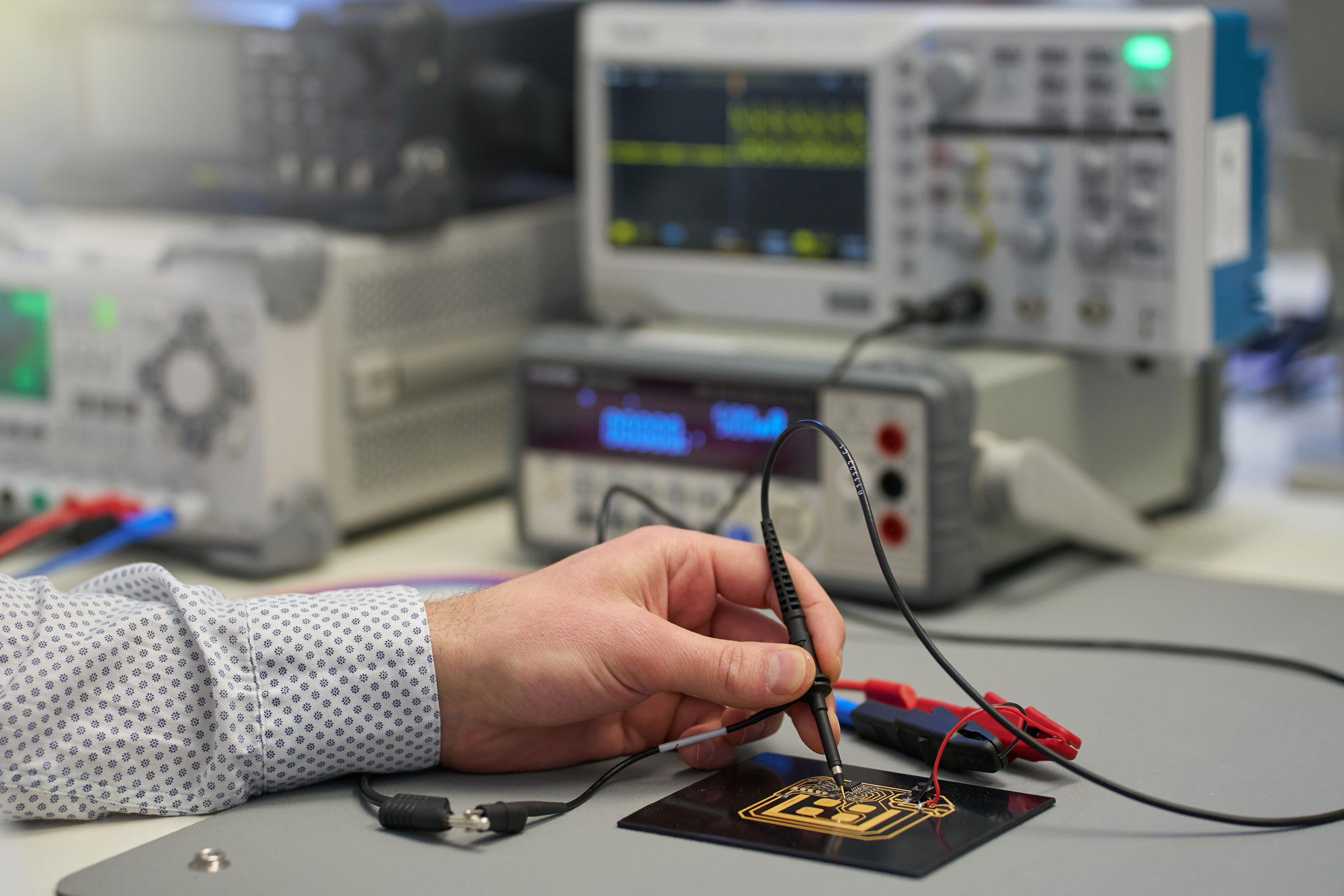 News Alu4ced Hand hält einen Stift und fährt damit über eine Platine.