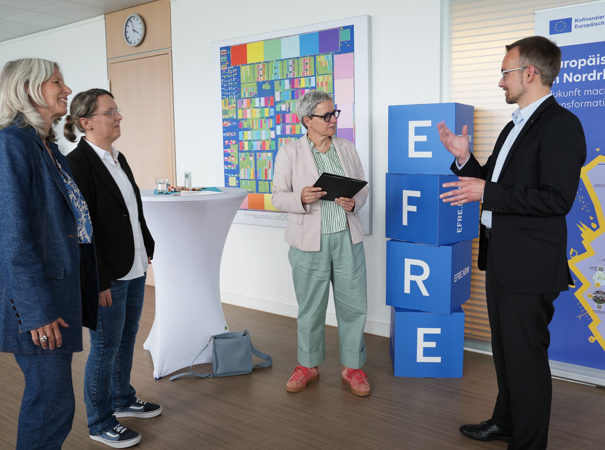 Besprechung_Efficynet Vier Menschen unterhalten sich.