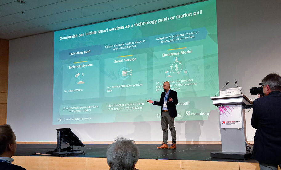 Vortrag Roman Embedded World Conference Prof. Roman Dumitrescu steht auf einer Bühne und hält einen Vortrag.