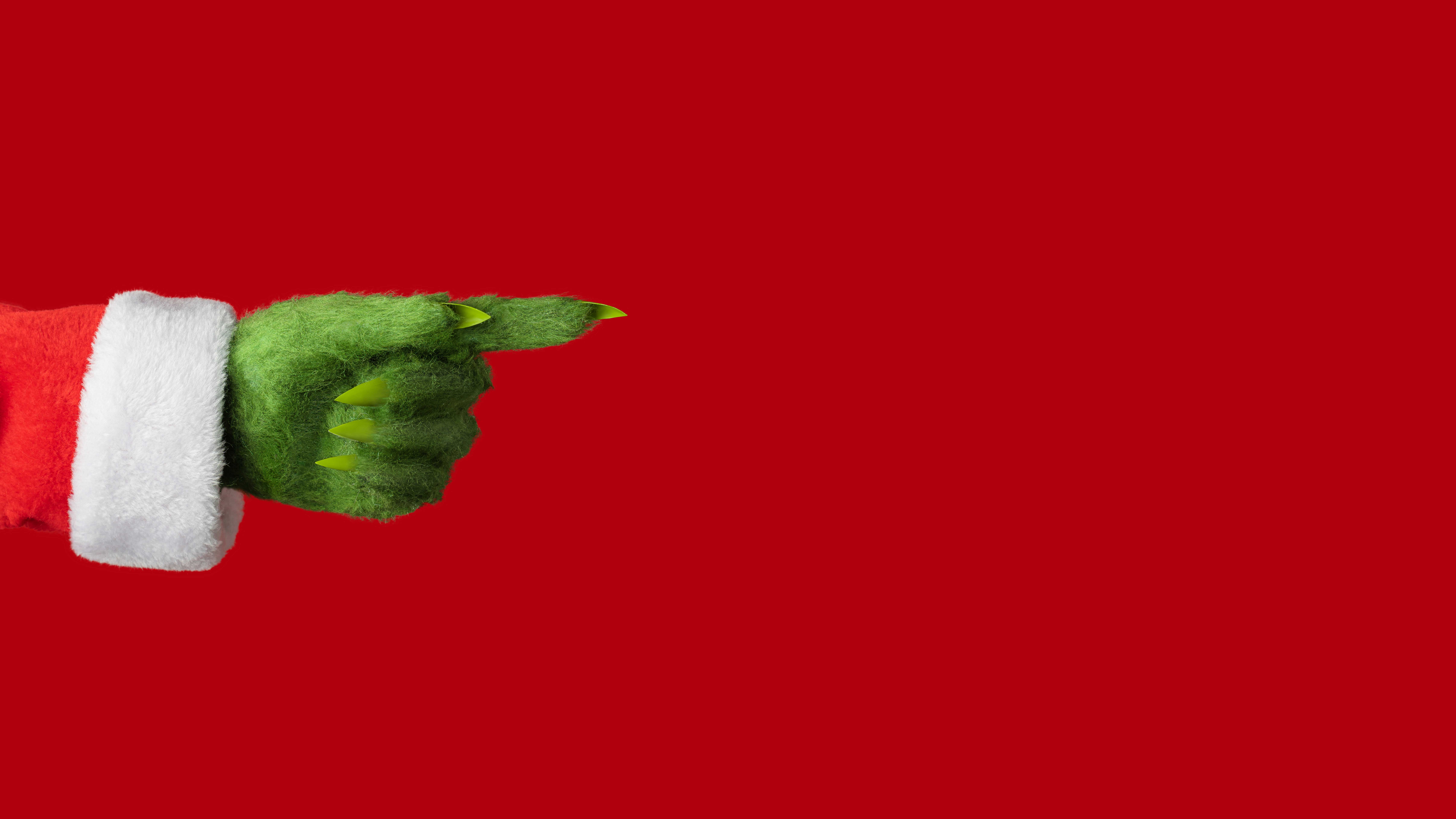 News Technologien für das Weihnachtsfest Eine grüne Hand in Weihnachtsmannkostüm zeigt nach rechts.