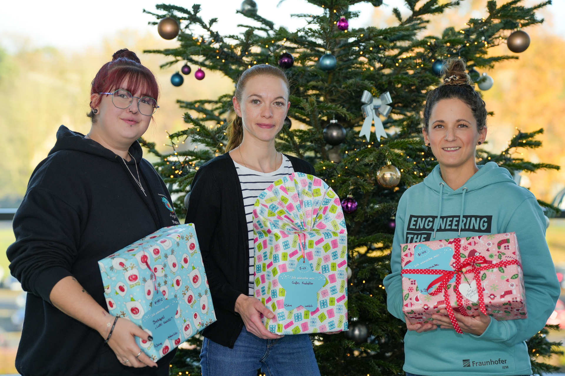 Unterstützung der DRK-Weihnachtsaktion: Yvonne Kosbab und Ruth Köler (beide Paderborner Jugendrotkreuz) nehmen die Weihnachtsgeschenke des IEM-Teams von Anell Bernard (Fraunhofer IEM) entgegen. 