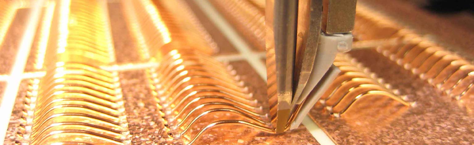 Detail einer Maschine, welche goldenen Draht formt