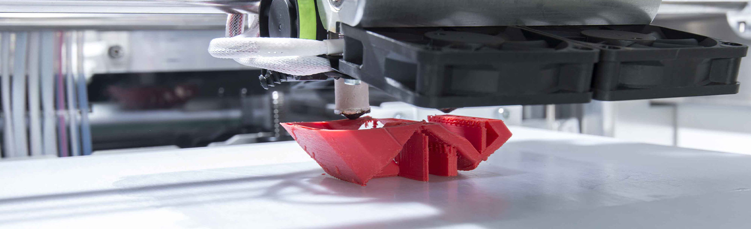Detailansicht eines roten Exponates im 3D-Drucker
