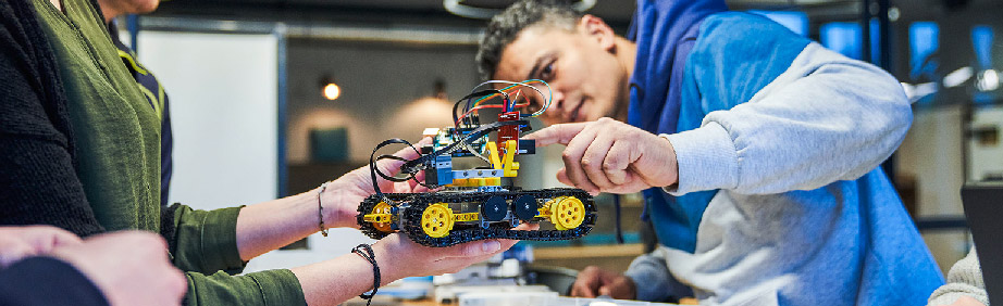 A man points to a technical Lego model.