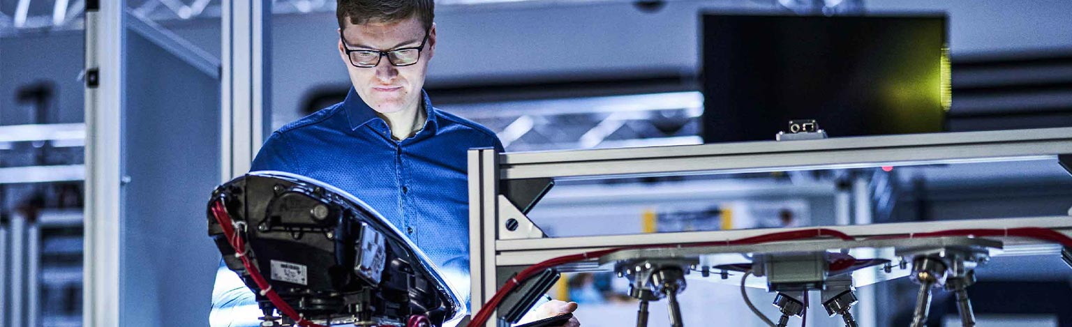 Man in front of a machine in an industrial environment.